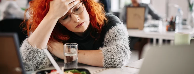 Chica pelirroja cansada en la oficina por un bajón de energía